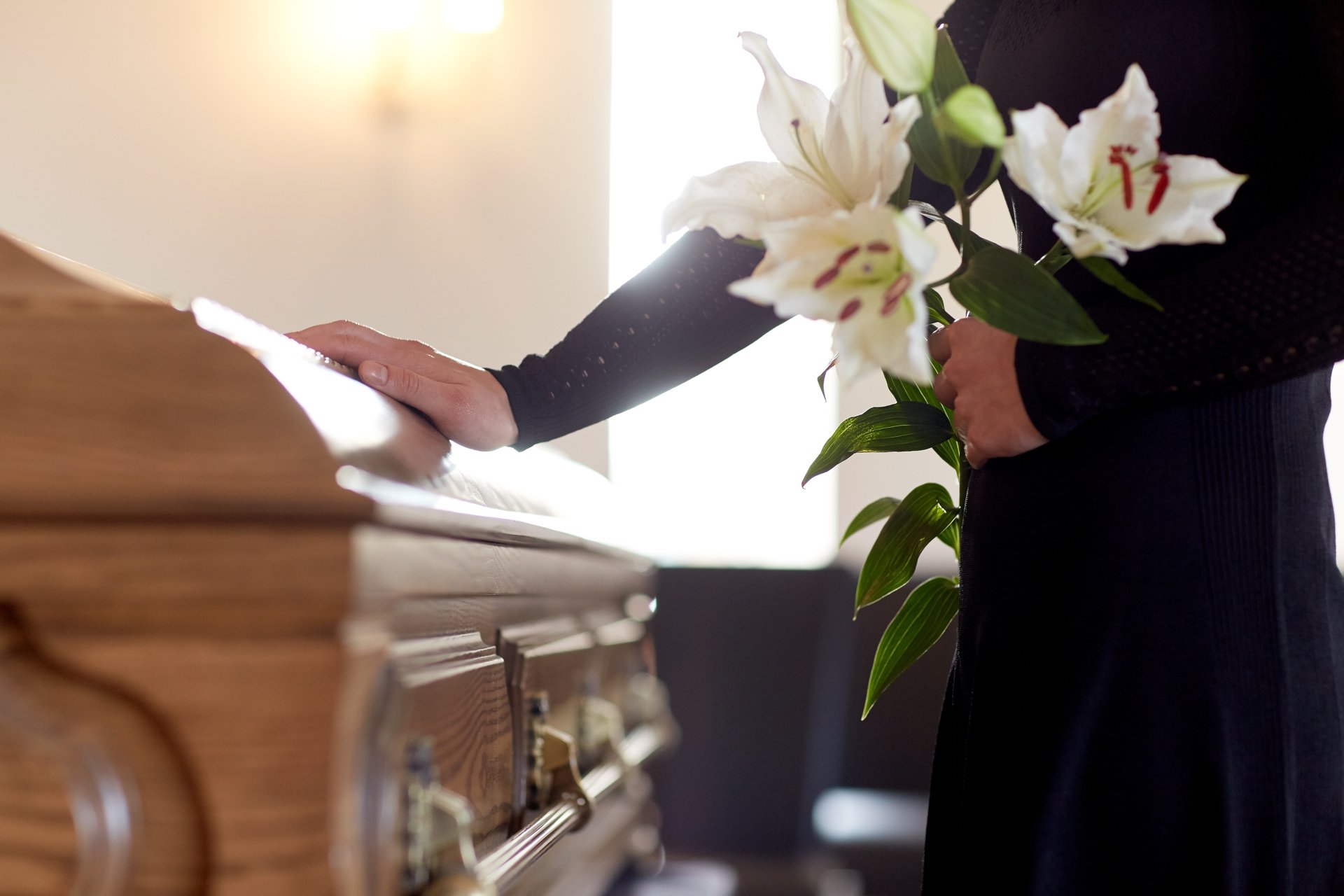 Woman touching a casket at a funeral