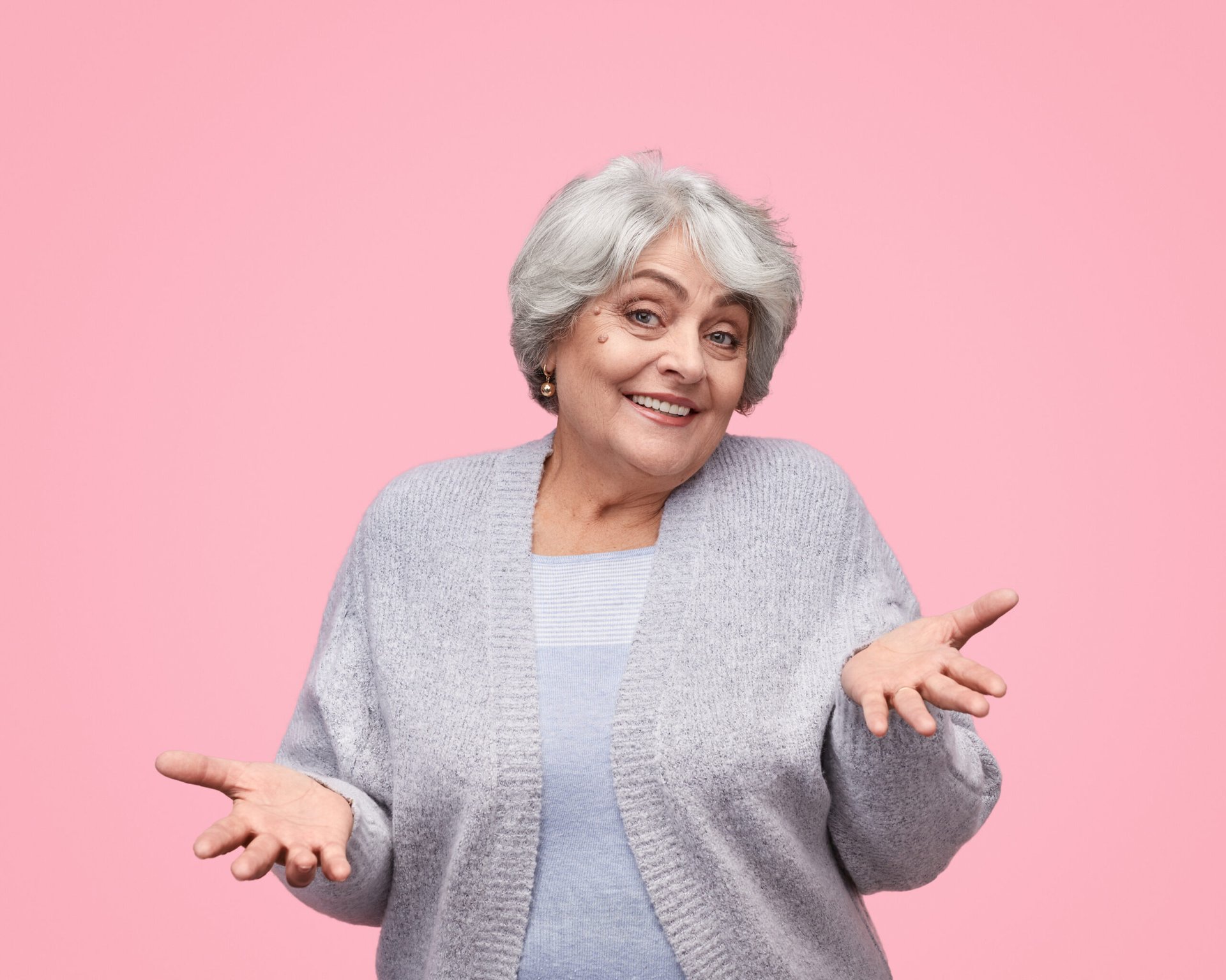 Senior woman retiree shrugging and smiling