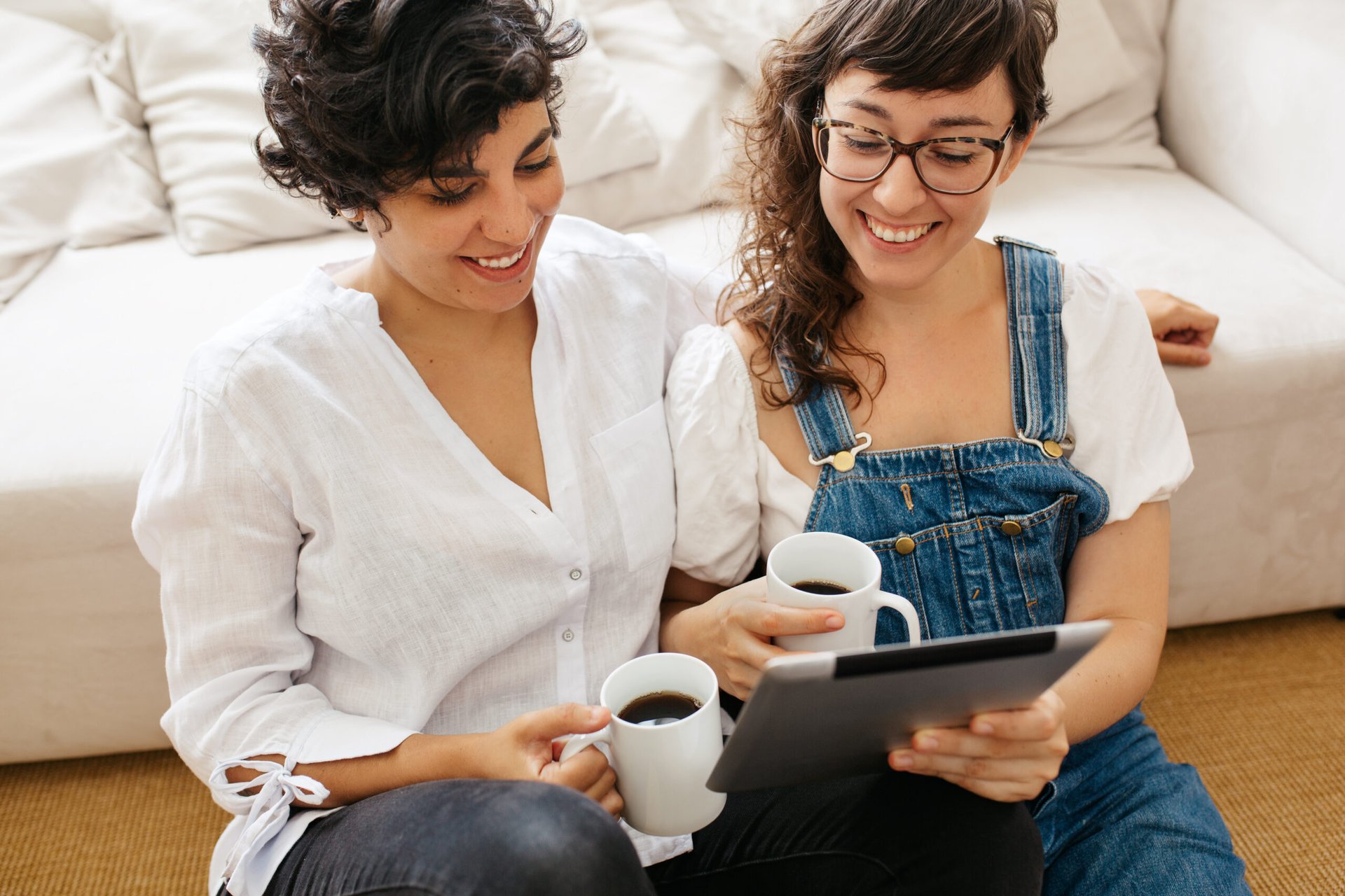 Couple using a tablet computer while drinking coffee