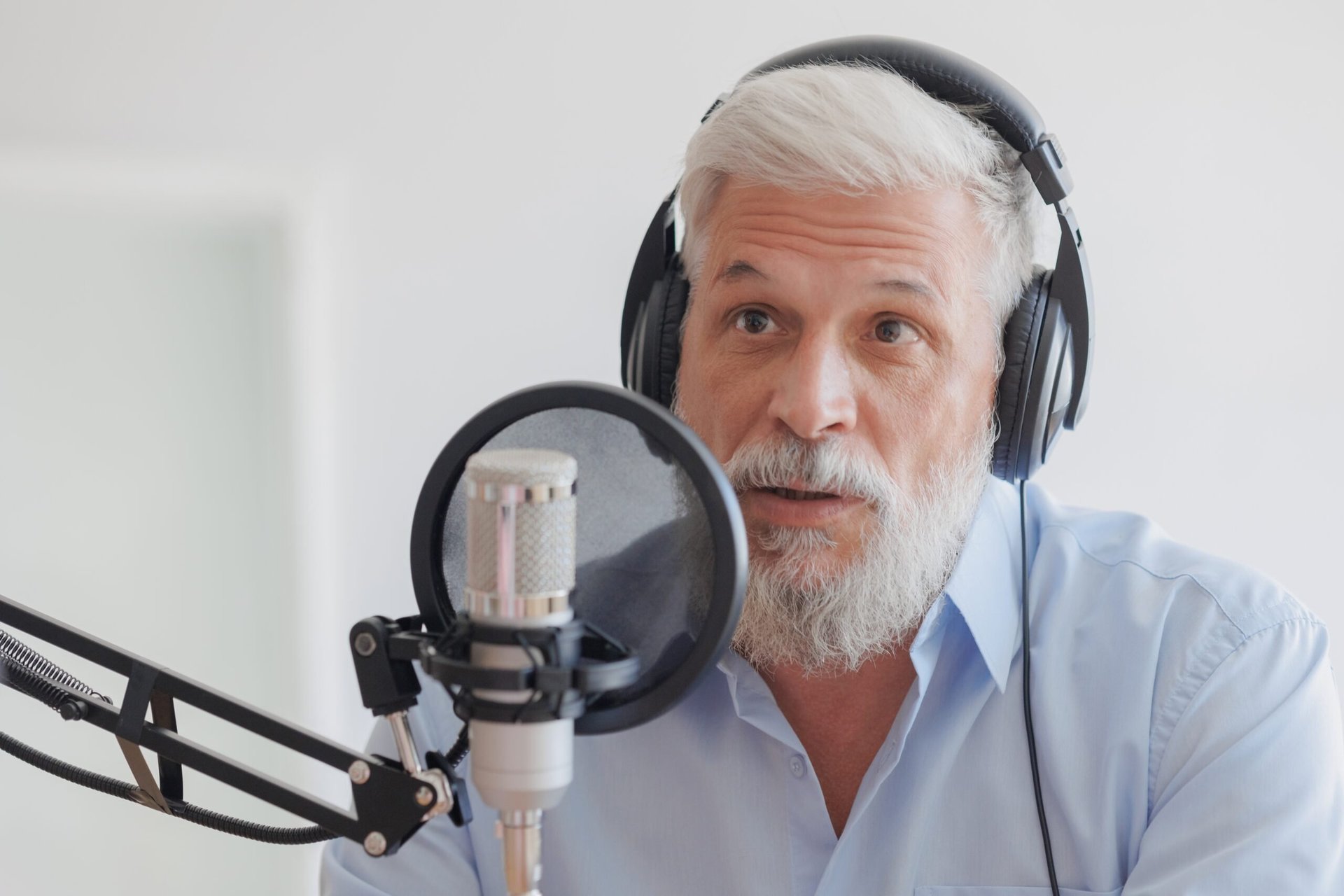 Older man speaking into a microphone