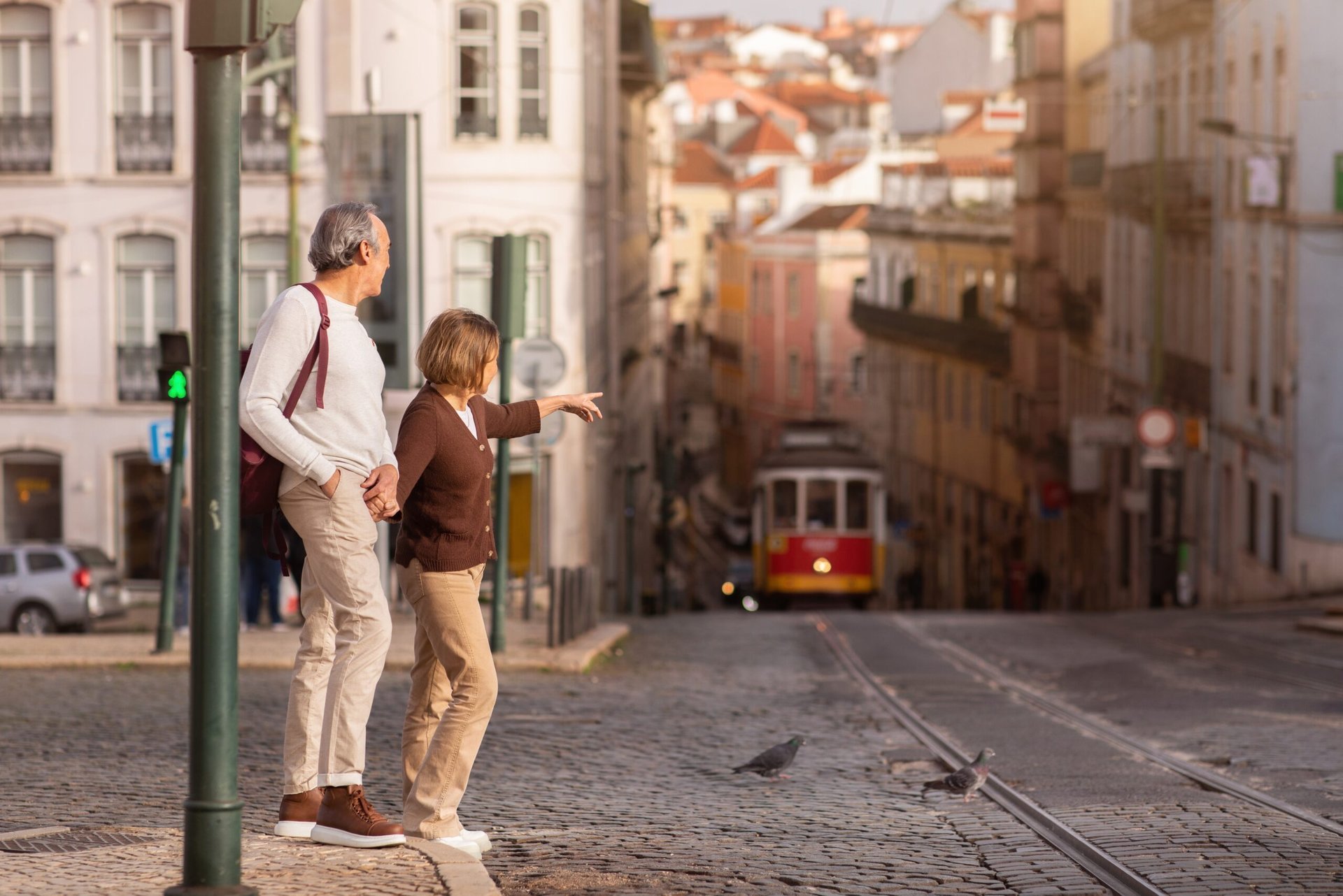 Senior couple in Lisbon, Portugal with a tram in the background.