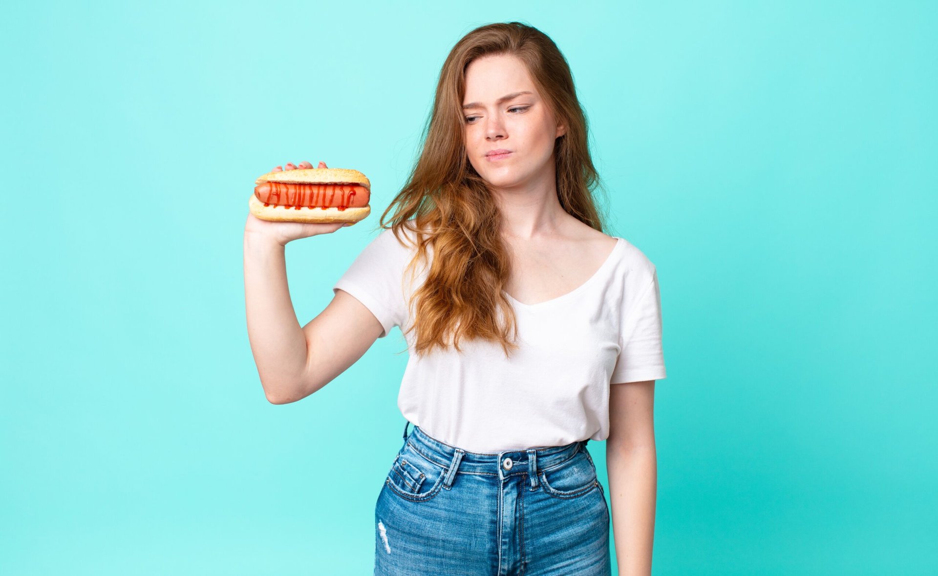 Woman looking concerned at hot dog.