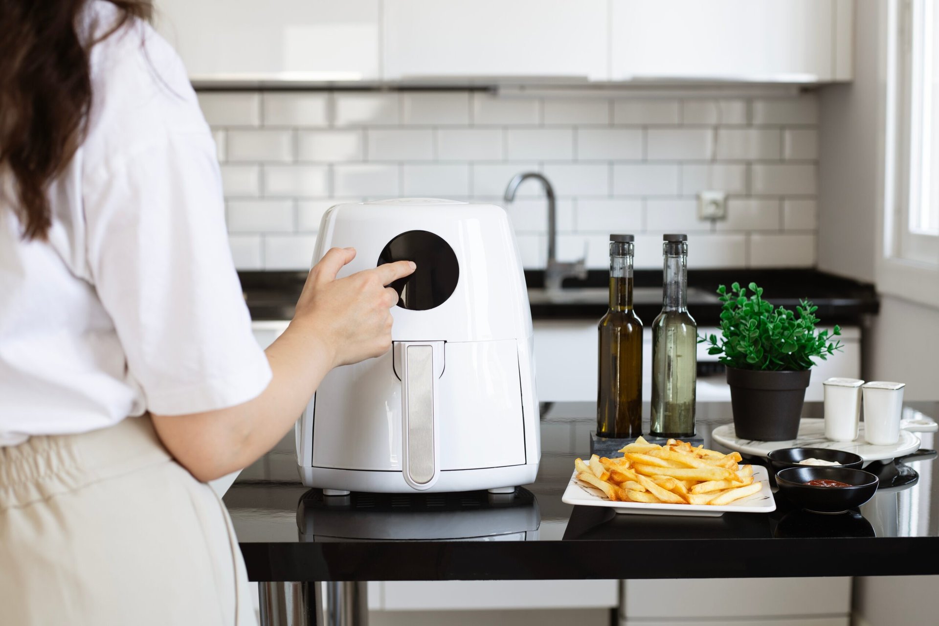 woman reheating french fries in air fryer