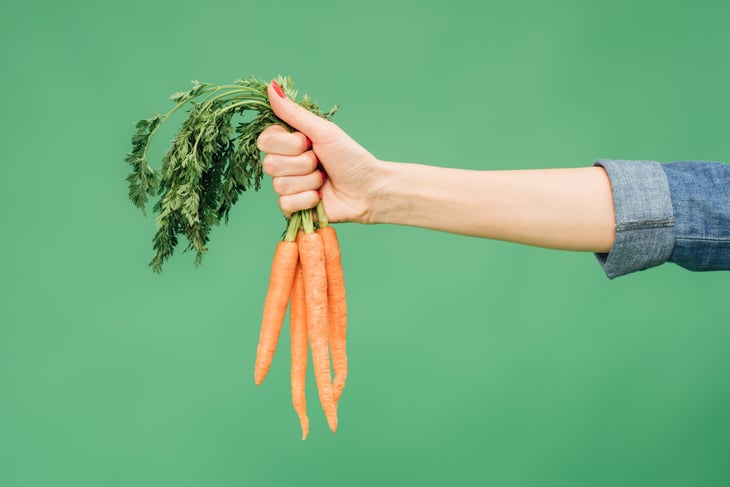 Woman holding carrots.